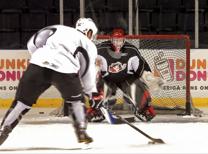 Reporter Bob Keyes survives a stint in the goal during a Portland Pirates practice.
