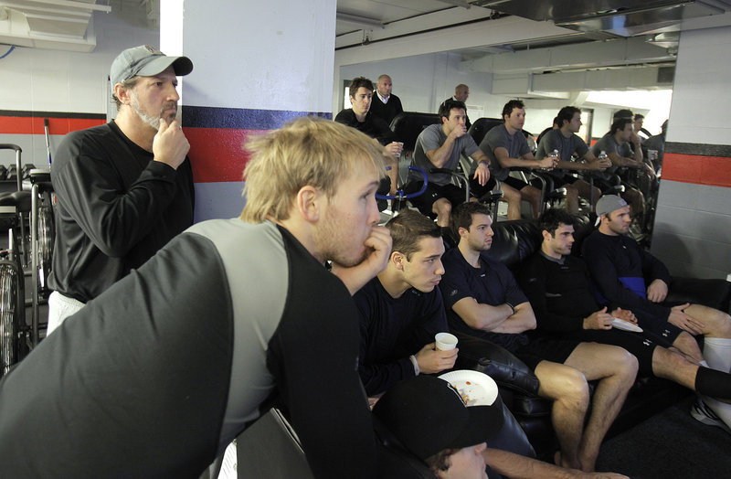 Reporter Bob Keyes, far left, listens during a pre-practice meeting with the Portland Pirates before taking the ice.