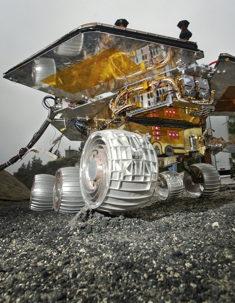 A full-scale copy of Spirit and Opportunity, the twin robot explorers that landed on Mars seven years ago, rolls over a small rock at a mockup of the Martian surface in a parking lot behind the Jet Propulsion Laboratory in Pasadena, Calif., in 2003.