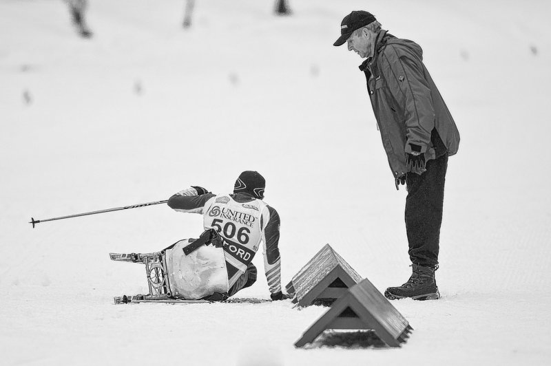 Marlon Shepard recovers from a spill during a race Sunday in Rumford as a course worker checks to make sure he’s OK. Shepard is scheduled to race a 15-kilometer event Wednesday.