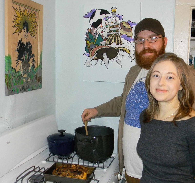 Luke Fuller and Cassi Madison prepare a chili using all Maine ingredients in their West End kitchen. Fuller, who is an artist, created the artwork above the stove. The piece on the left depicts the late Jim Cook, who founded the Crown O'Maine Organic Cooperative.