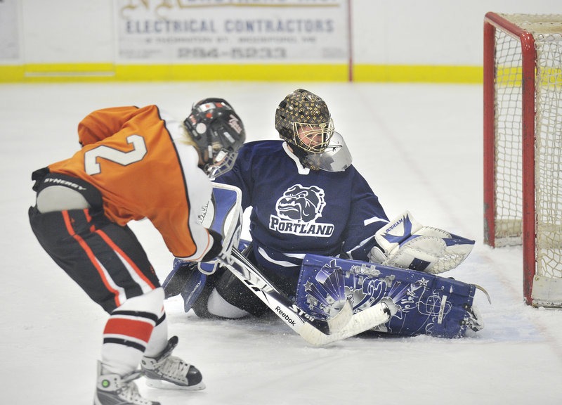 The Tigers’ Haley Reny has her point-blank shot blocked by Bulldogs goalie Courtney Rickett in the second period Monday at Biddeford Ice Arena.