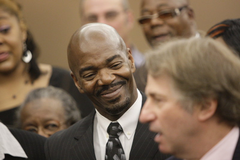 Cornelius Dupree Jr., 51, center, smiles as attorney Barry Scheck, right, speaks in Dallas on Tuesday. Dupree – who could have been paroled earlier had he not maintained his innocence in a rape and robbery – served more time for a crime he didn’t commit than any other Texas inmate exonerated by DNA evidence.