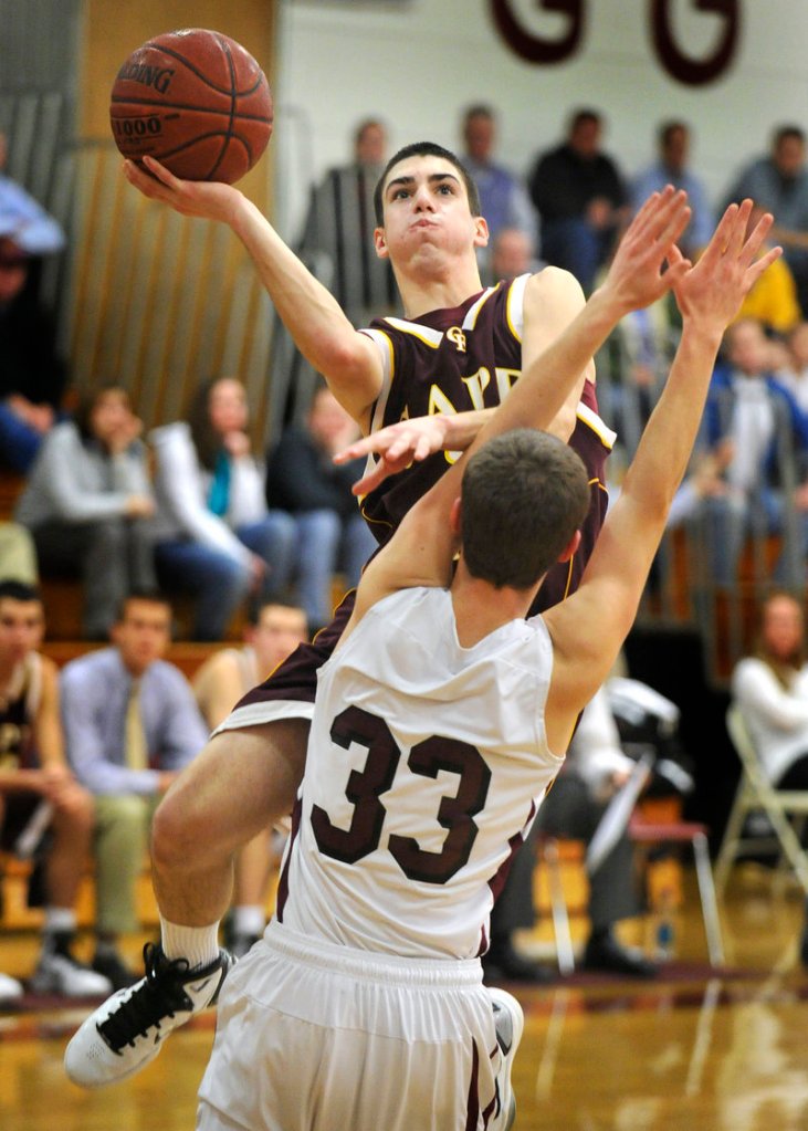Cam Brown of Cape Elizabeth heads over Brad McKenney of Greely for a basket Tuesday during Cape Elizabeth’s 55-41 victory at Cumberland. Each team is 5-1 in the tight Western Class B race.