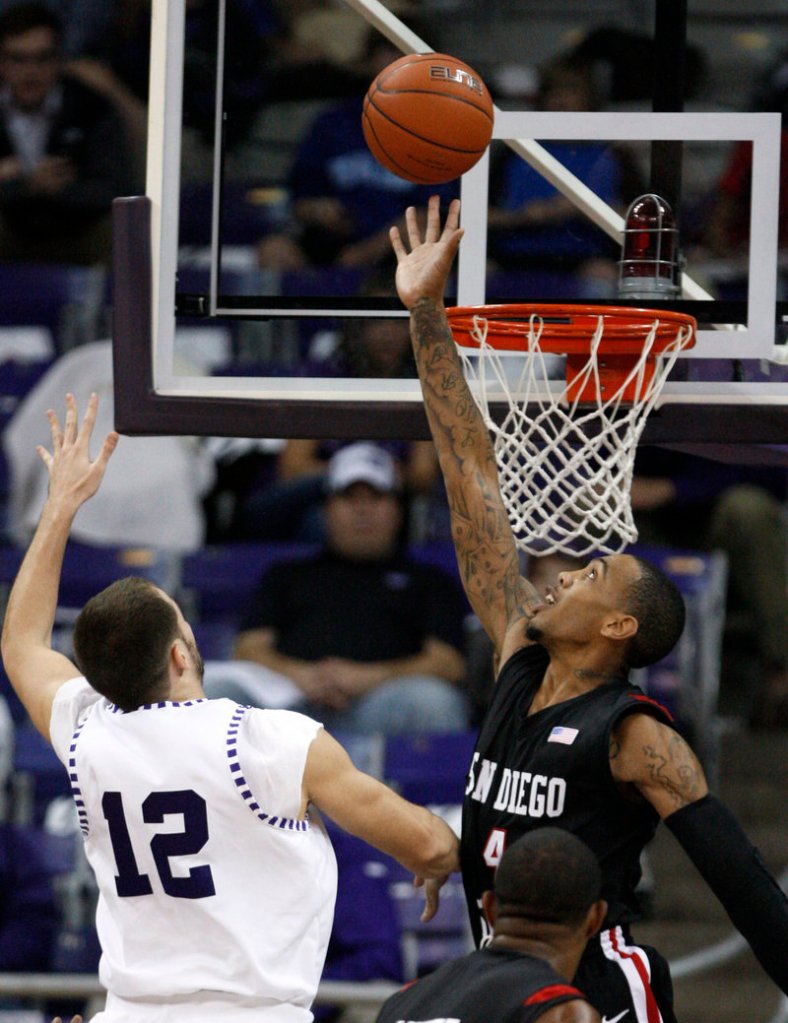 Nikola Gacesa of TCU, left, puts up the shot, and Malcolm Thomas of San Diego State goes up for the block Wednesday in Fort Worth, Texas. San Diego State won, 66-53.