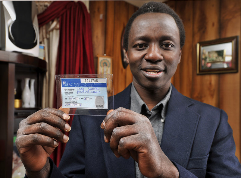 Lado Ladoka of South Portland, holding his Sudanese voter registration card, says Sunday’s secession vote is “a piece of history everyone is clinging to.”