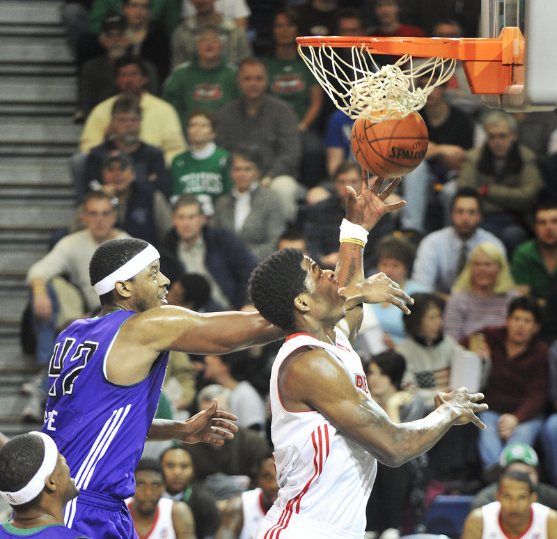 DeShawn Sims of the Maine Red Claws is fouled by Walter Sharpe of the Dakota Wizards while going up for a shot Thursday night. Maine won 99-95 in overtime at the Expo.