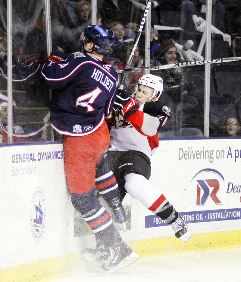 Maxime Legault of the Pirates, right, collides against the boards with Springfield s Nick Holden in second-period action at the Cumberland County Civic Center on Friday. Legault had a goal in the 4-1 Portland win.