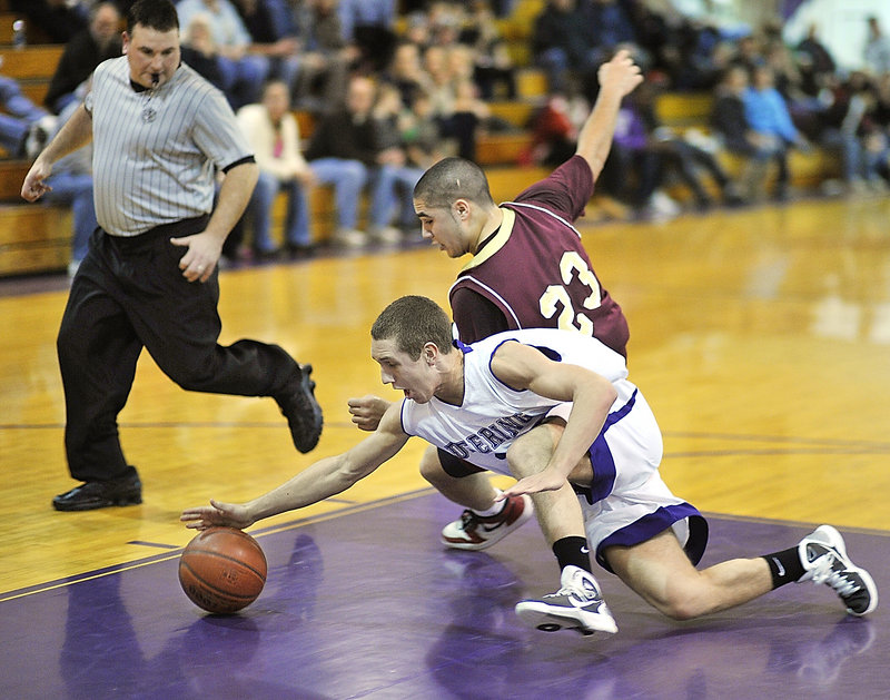 Eddie Flaherty of Deering reaches for a loose ball Friday night ahead of James Ek of Thornton Academy as referee Dan Boomhour keeps an eye on the play. Deering came away with a 50-48 victory at home.