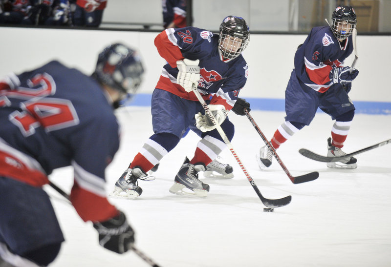 Defenseman Evan Coulombe, center, of Gray-New Gloucester/Poland leads a rush while flanked by two teammates. The Patriotic Knights improved their record to 6-2.