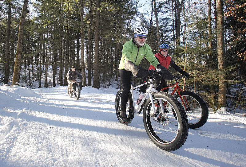 Jeff Clarke, left, Glenn Fenlason, center, and Brian Alexander ride winter bikes in the Quarry Road Recreation Area in Waterville. The bikes use fatter tires for better traction in the snow.