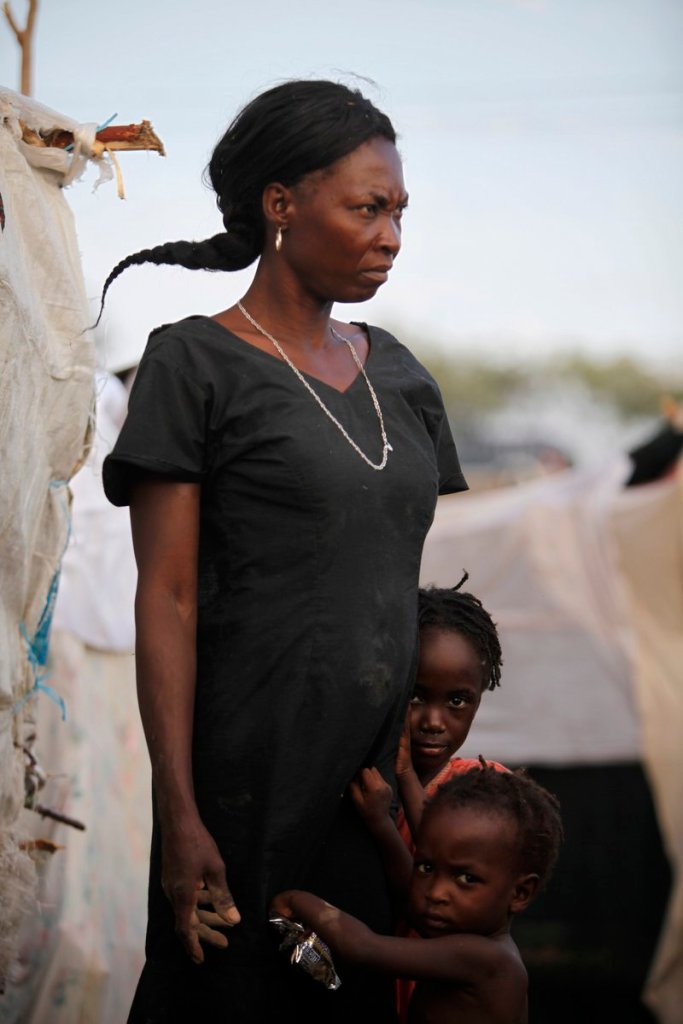 Dielisia Pierre stands with her children last February while taking shelter at a camp for earthquake survivors in Port-au-Prince. The magnitude 7.0 quake, which occurred a year ago today, left millions homeless.