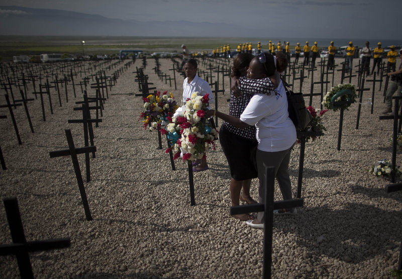 Two women embrace Tuesday during a religious ceremony at the Titanyen mass grave site on the outskirts of Port-au-Prince. It is one of many events planned to mark the one-year anniversary of the Jan. 12th earthquake that killed more than 220,000 people.