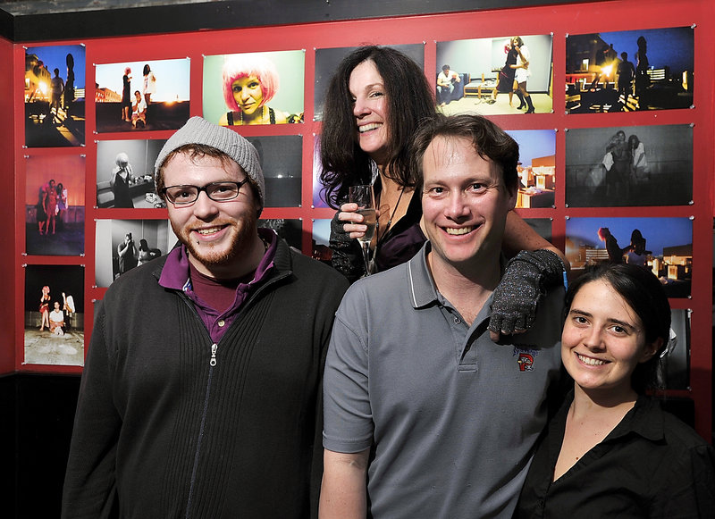 A few friends join Ian Farnsworth, second from right, at his club, the Slainte Wine Bar and Lounge on Preble Street in Portland. They gathered for the opening of photographer Robbie Kanner’s exhibit at Slainte, seen behind them. From left are Kanner, musical performer Robin Ivy, Farnsworth and bartender Katrina Abramo.