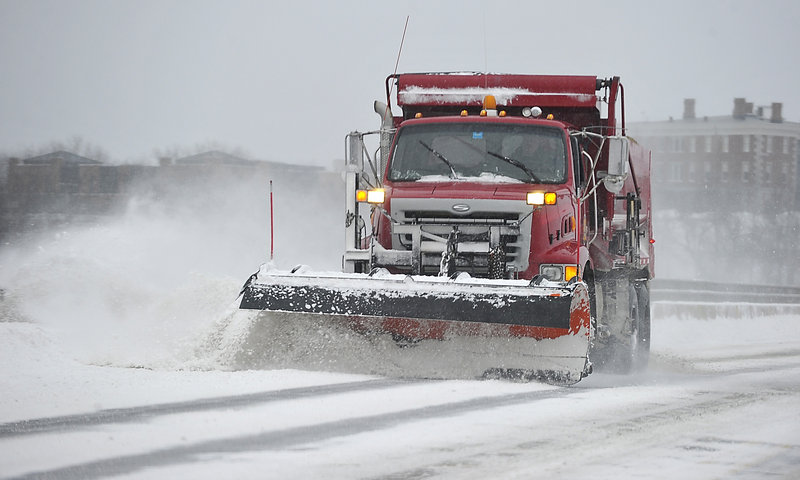 A snowplow cleans the road crossing Martin’s Point Bridge between Portland and Falmouth. Public works crews in several municipalities spread sand and salt on the streets even before the first flake fell to minimize slippery conditions.