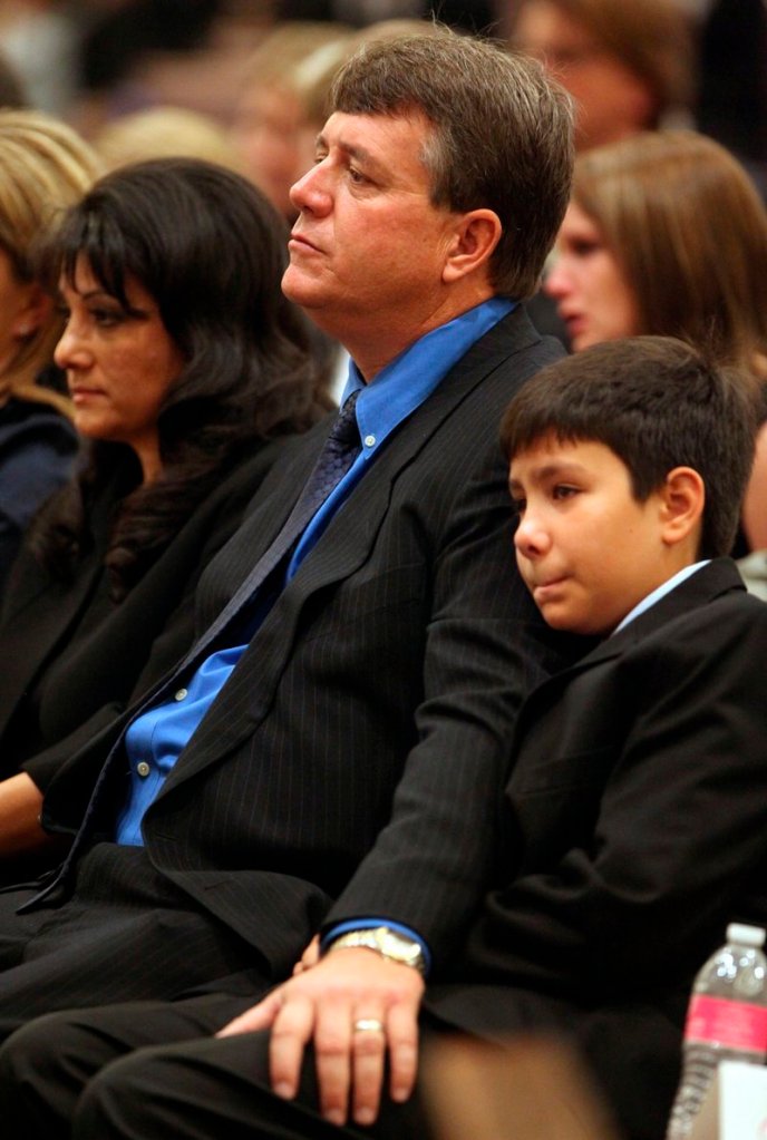 John Green rests his hand on his son Dallas’ leg during the funeral of his daughter, 9-year-old Christina Taylor Green, on Thursday in Tucson, Ariz. Christina Taylor Green, the youngest victim of Saturday’s shooting in Tucson, was felled by a gun with a 33-round magazine fired by Jared Loughner.