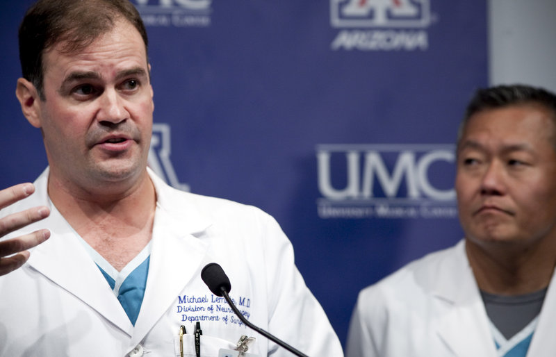 Rep. Gabrielle Giffords’ neurosurgeon, Dr. G. Michael Lemole, Jr., left, at a news conference Thursday called her responses “a major milestone” in her recovery.