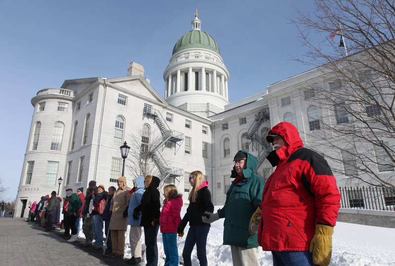 Participants gather outside the State House on Saturday for the annual Hands Around the Capitol anti-abortion rally. The event marks the anniversary of the Roe v. Wade decision.