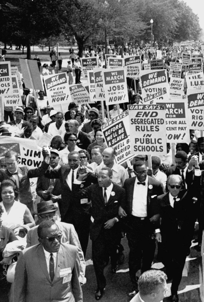 Dr. Martin Luther King Jr., third from right, marches in a line of men with arms linked during the March on Washington for civil rights on Aug. 28, 1963.