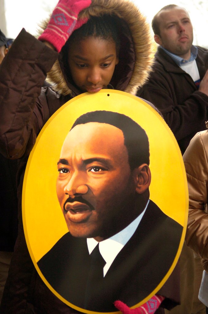 Amanda Beatty, 13, of Fort Wright, Ky., listens to speakers while holding an image of Dr. Martin Luther King, Jr. in Cincinnati on April 4, 2007, before taking part in a walk across a bridge over the Ohio River.