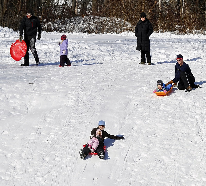 Sledders queue up to try the sledding hill at Fort Williams Park in Cape Elizabeth.