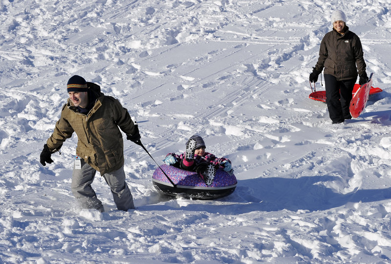Matt and Carmensol Kesselhout of South Portland enjoy one of the several sledding hills at Fort Williams Park with their children Maximo, 8, and Isabel, 6, who is being pulled up the hill by her father.