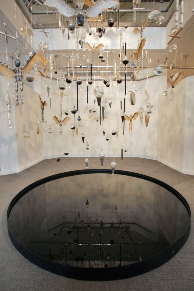 Alison Hildreth's hanging installation at the University of New England is suspended over, and reflected in, a shallow pool.