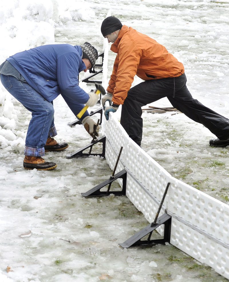 Jim Heard and Roy install brackets while putting the rink together with other volunteers.