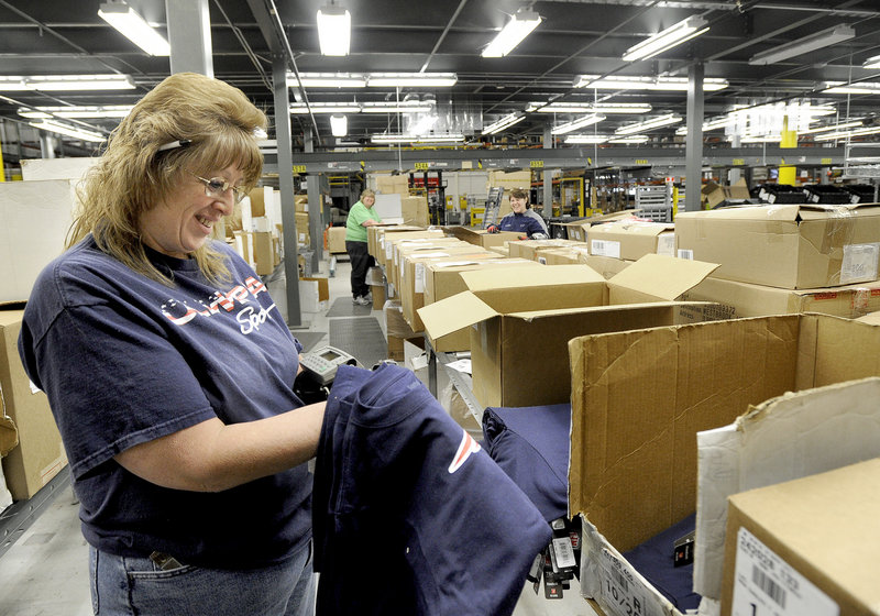 Wendy Levasseur sorts T-shirts at Olympia Sports’ distribution center in Westbrook. Olympia ships an average of 4,000 boxes to stores each day.
