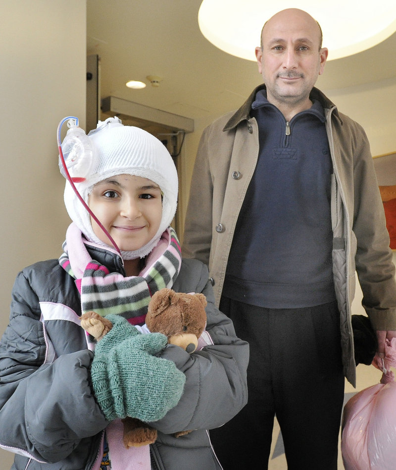 Noora Abdulhameed and her father, Afef, leave Maine Medical Center on Friday. The Iraqi 9-year-old has had 14 surgeries in this latest, and possibly last, trip to Portland.