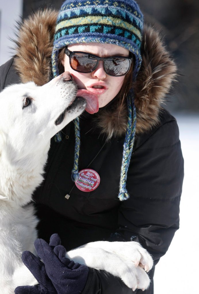Alyssa Janelle of Falmouth gets a kiss from a pup while waiting to participate in the “Freezing for a Reason” polar dip.