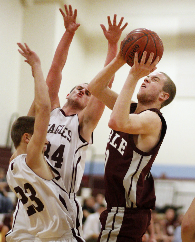Mitch Edmunds of Noble gets off a shot Saturday while guarded by Ben Noble, left, and Kyle Williams of Windham. Edmunds scored 26 points as Noble came away with a 60-39 victory at Windham.