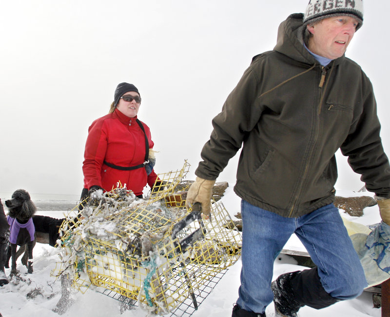 Sarah Mosley of Westbrook and Iver Carlsen of Scarborough, members of the Surfrider Maine Foundation, remove a lobster trap during a cleanup at Scarborough’s Higgins Beach on Sunday. The nonprofit group cleans a different beach each winter.