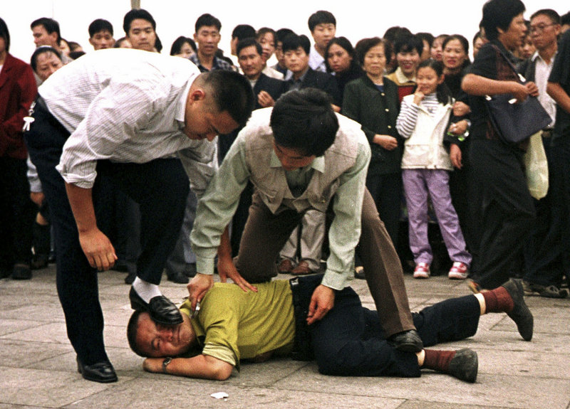 Police detain a Falun Gong protester in Beijing in 2000. Human Rights Watch decries “the near-universal cowardice in confronting China’s deepening crackdown on basic liberties.”