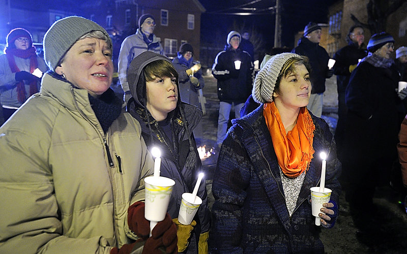 Ellen Wolfe, left, and her children Jacob, 12, and Katy, 17, listen as her husband and their father, Britt Wolfe, principal of Biddeford High School, speaks at a vigil in Biddeford on Monday night.