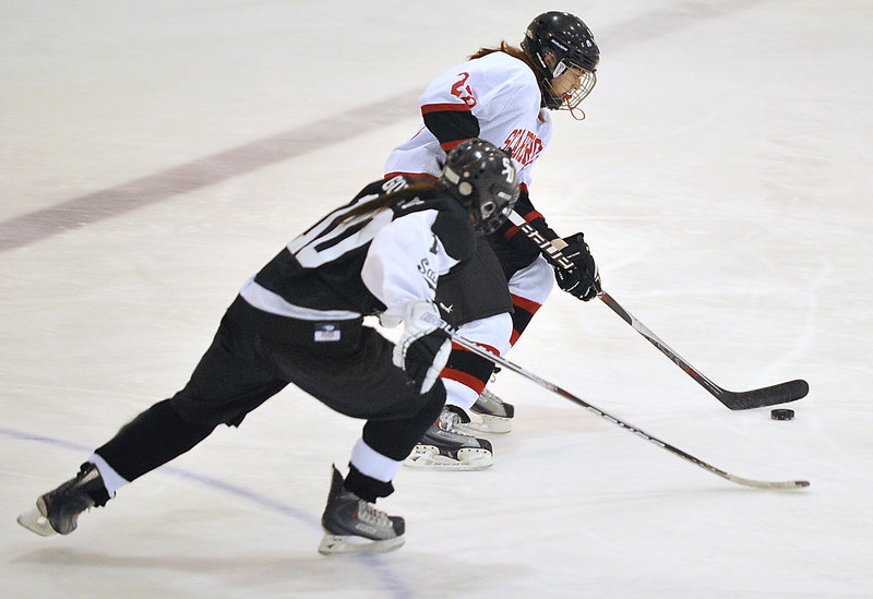 Kristina Block of Scarborough carries the puck through the neutral zone while being pursued by Sophie Goulet of St. Dom’s.