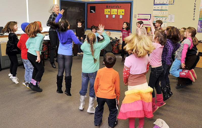Alyson Ciechomski, music teacher at Longfellow Elementary School in Portland, leads a lesson on musical elements like timing and rhythm as first- and second-graders jump to a classical “Pop Goes the Weasel” orchestral instrumental with their teacher.