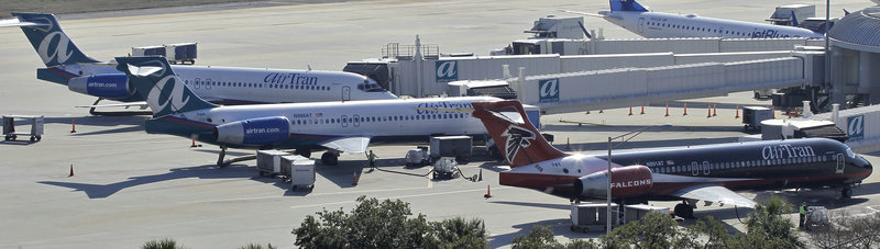 Three AirTran Airways jetliners sit at their gates last week at the Tampa International Airport in Tampa, Fla. U.S. airlines are in the midst of reporting fourth-quarter results that should cap the industry’s first moneymaking year since 2007.