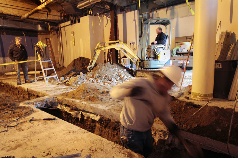 Workers excavate the future site of a Five Guys Burgers and Fries on Fore Street in Portland. The chain restaurant will open this spring.