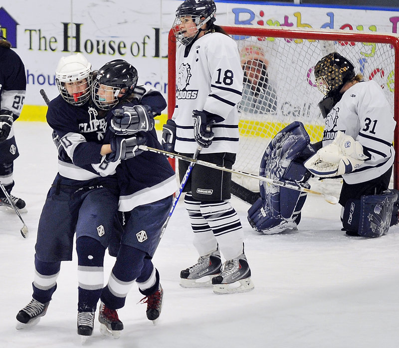 Arie Potter, right, receives a hug from Courtney Barker after scoring with one second to play Wednesday, giving Yarmouth a 6-5 victory against Portland at the Portland Ice Arena. It was Potter’s fifth goal of the game. The Portland players are goalie Courtney Rickett and Abbi Scrutchfield.