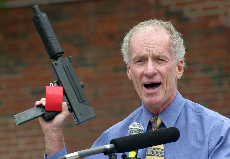 Former Portland police chief Michael Chitwood holds a MAC-10 automatic pistol with a silencer and an extended magazine seized in a raid by his deparment.