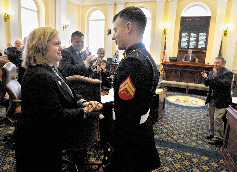 Sen. Deb Plowman, left, shakes hands with Marine Cpl. Joshua Carrier after he was introduced to legislators Thursday in Augusta. Carrier visited the State House after returning from combat duty in Afghanistan. Carrier, who has been deployed overseas twice in his three and a half years in the Marine Corps, needed his parents' signature when he joined the Corps at the age of 17. When his four years are up in June, the 2007 graduate of Erskine Academy plans to go to college. He serves with the 2nd Battalion, 6th Marine Regiment.