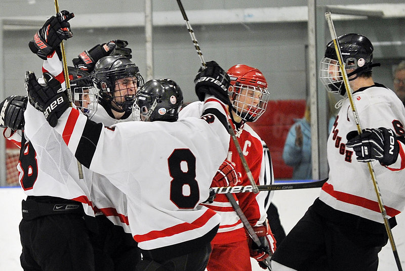Tommy Ellis of South Portland can only skate by Thursday night as Scarborough celebrates a second-period goal that tied the game. Jacob Gross, left, scored it, with Connor Gullifer, 8, and Kyle Nablo celebrating.