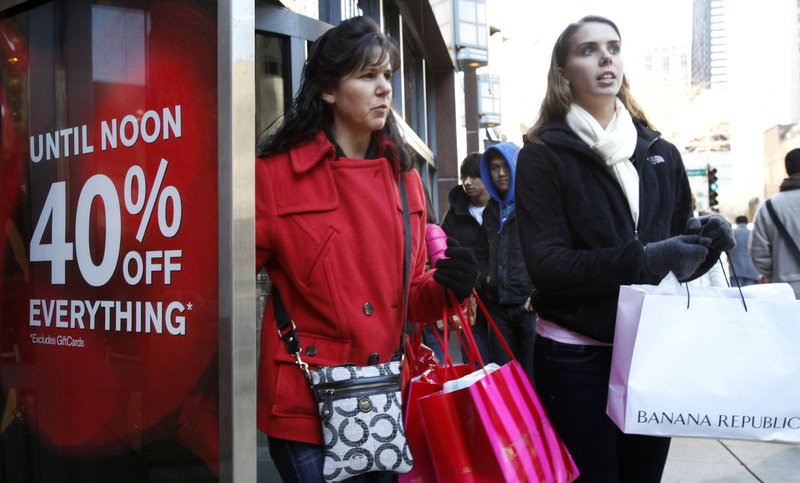 Shoppers walk out of the Express women's apparel store on Chicago's Magnificent Mile in November. The economy gained strength at the end of last year as Americans spent at the fastest pace in four years and U.S. companies sold more overseas.