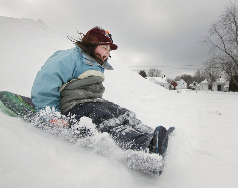 Sarah Younk, 9, slides at Walton Field on Saturday on the opening day of the Auburn Winter Festival. The hill is part of a snow playground created for the “celebration of everything winter” that continues through Feb. 6.