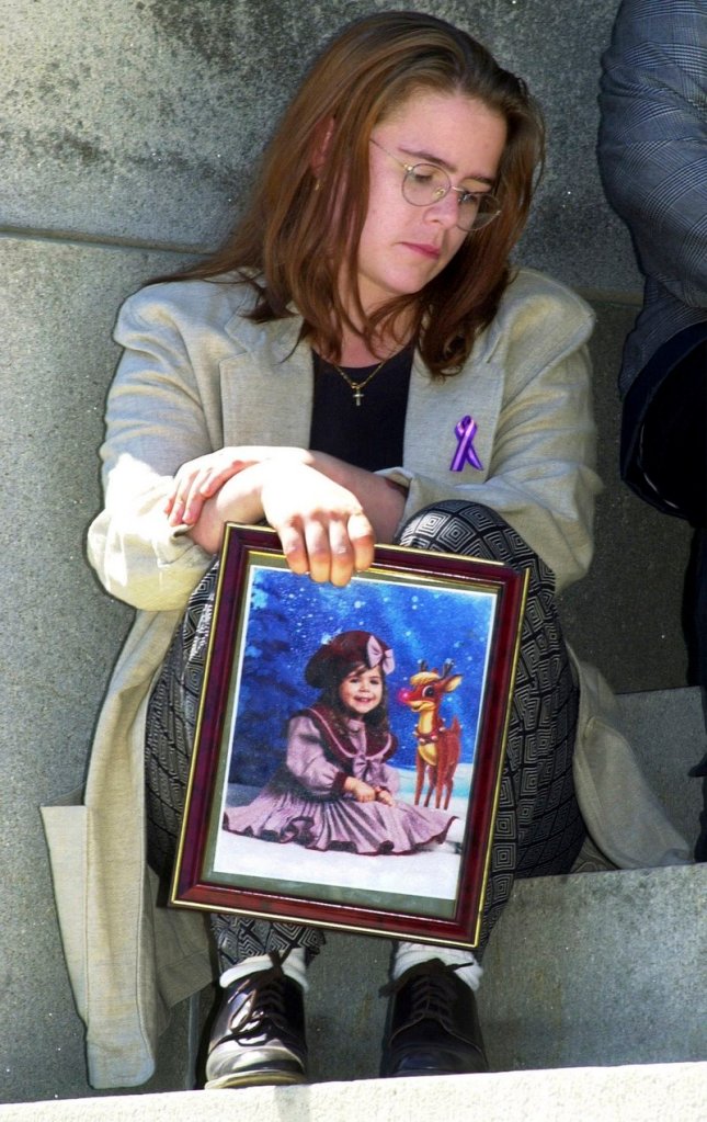 Christy Baker holds a photo of her daughter, Logan Marr, 5, after a news conference in April 2001. Logan Marr died on Jan. 31, 2001.
