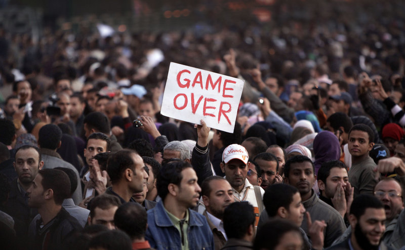 An anti-government protester holds a sign reading "Game Over" in Tahrir Square in downtown Cairo, Egypt, on Saturday.