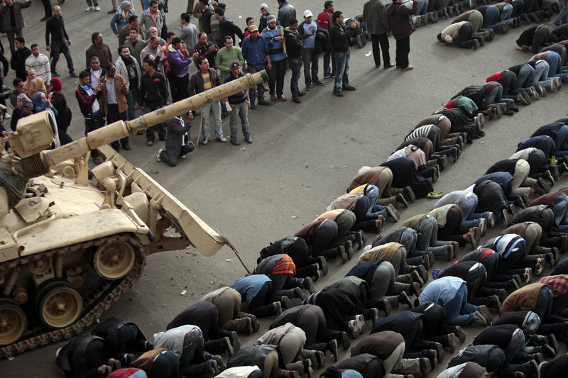 Anti-government protesters bow in prayer in front of an Egyptian army tank during a protest in Tahrir Square in Cairo on Saturday.