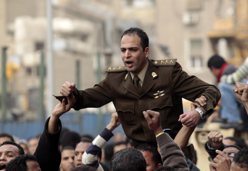 Egyptian anti-government protesters carry on their shoulders an Egyptian army officer who joined them in their protest in Tahrir square in Cairo, Egypt, on Saturday.