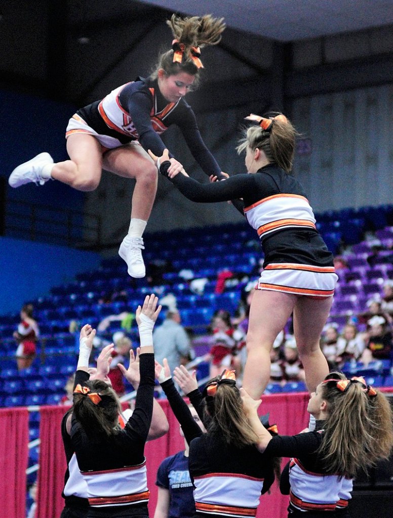Brunswick cheerleaders Margaret Mathy, left, and Kelsey Thibeault do a stunt Saturday during the Eastern Class A competition at the Augusta Civic Center.